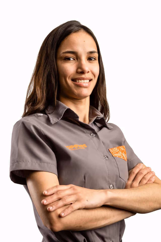 Profissional do Popeyes de braços cruzados; em seguida, a foto troca e ele(a) aparece segurando um balde de frango